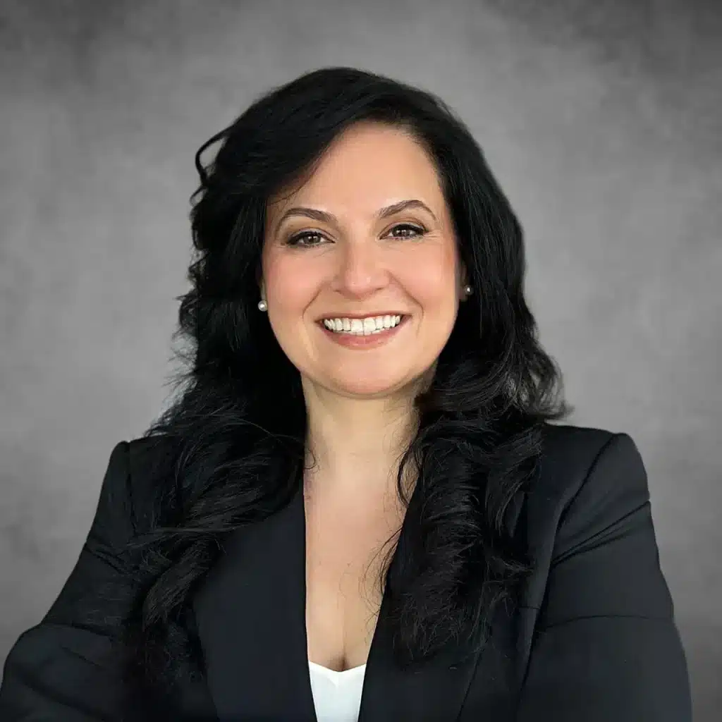 Natalie Nassi, Managing Partner at Easy Lemon, smiling confidently in a professional headshot with a gray background.