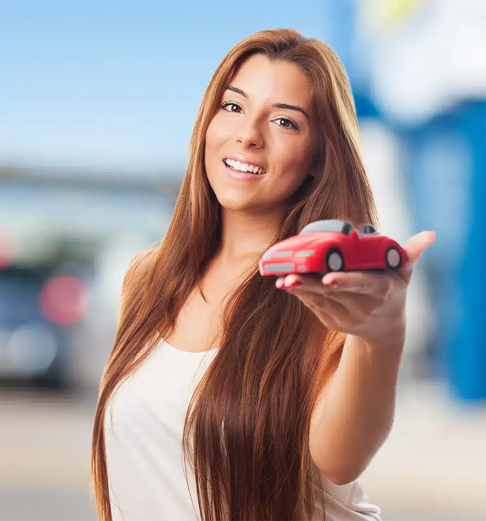 Smiling woman holding a toy car, symbolizing success and satisfaction after resolving Lemon Law issues