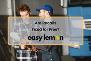Service advisor and car owner reviewing recall repair paperwork at a dealership service center