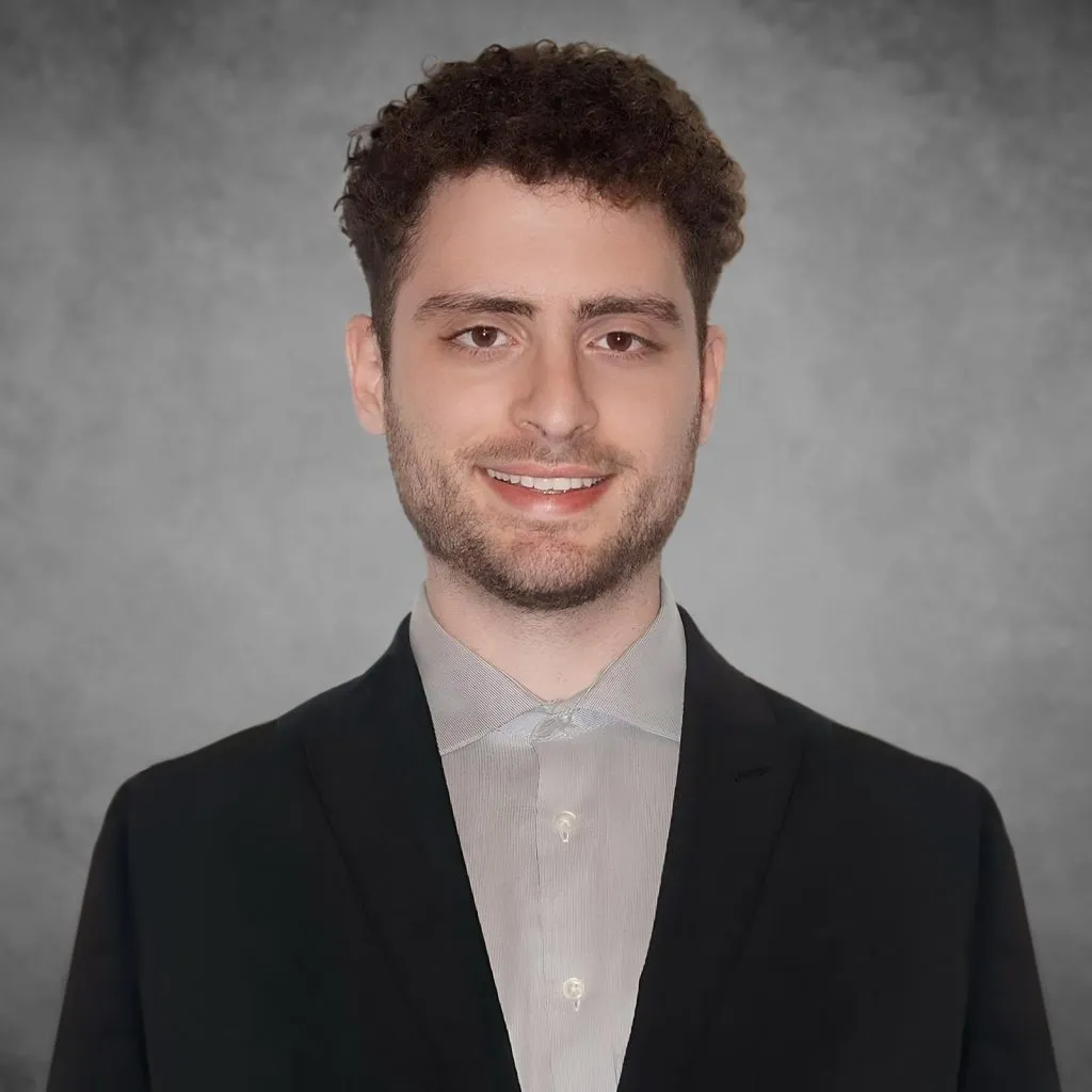 Professional headshot of Ben Saida, a marketing professional and Easy Lemon team member, wearing formal attire with a neutral gray background and a confident smile.