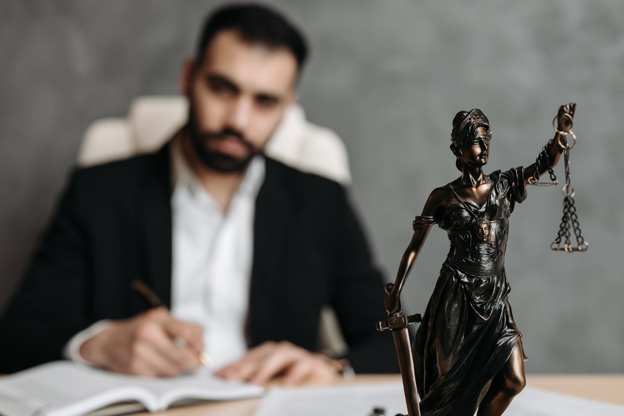 Dallas lemon law attorney reviewing vehicle warranty documents with Lady Justice statue on desk