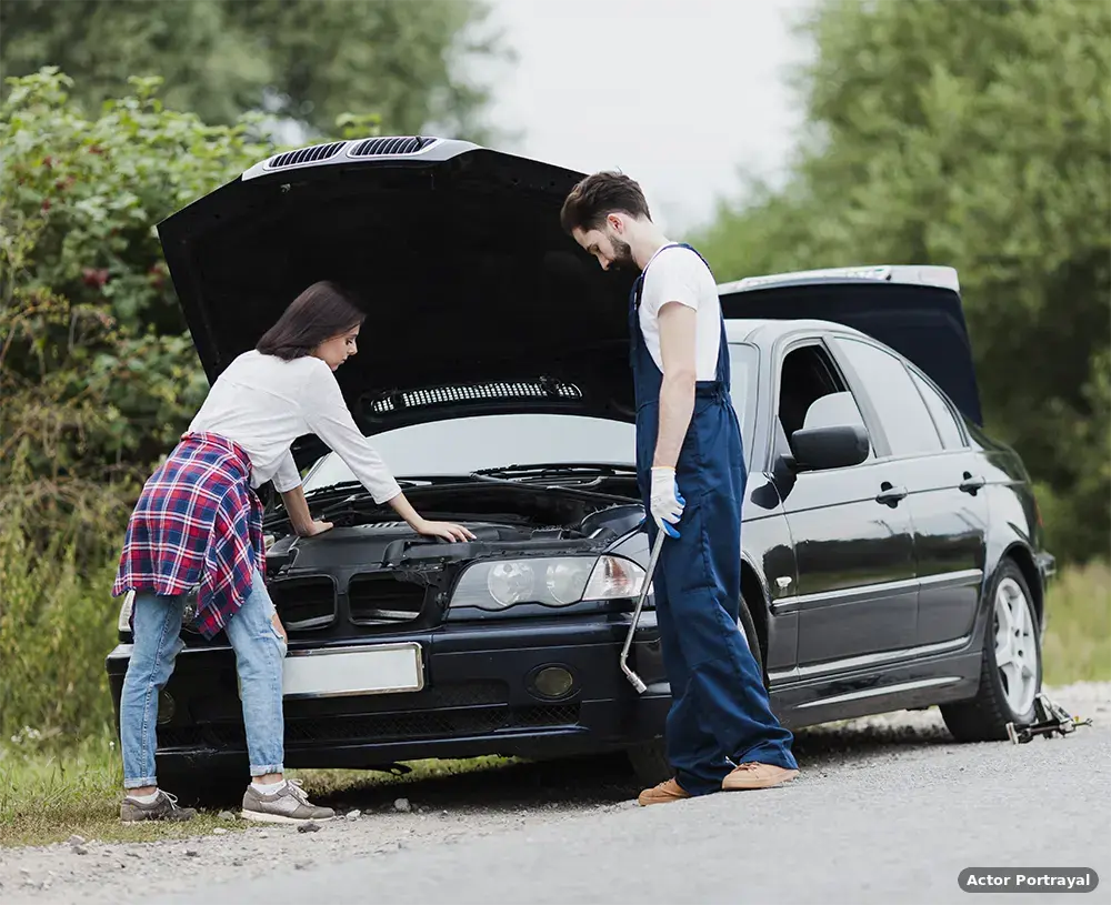 Driver and mechanic inspecting defective car engine (Actor Portrayal)