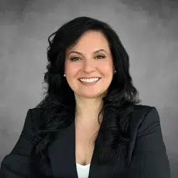 Natalie Nassi, Managing Partner at Easy Lemon, smiling confidently in a professional headshot with a gray background.